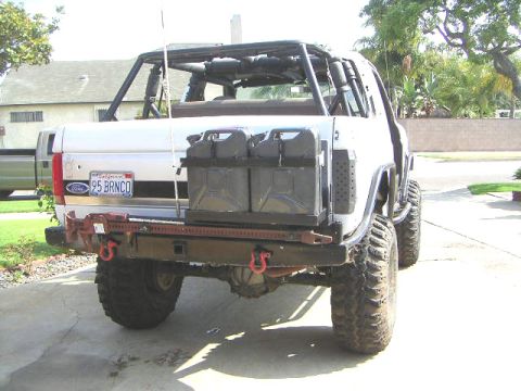 1991 Ford Bronco - Rear view of a modified white Ford Bronco with a custom roll cage and auxiliary fuel cans.