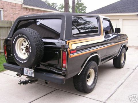 1993 Ford Bronco - This black Ford Bronco from 1978 features a spare tire mounted on the rear door and distinctive side striping.