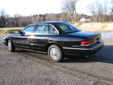 1991 Ford Crown Victoria LTD - This black sedan, likely a 1992 model, is viewed from the rear three-quarter angle on a gravel surface.