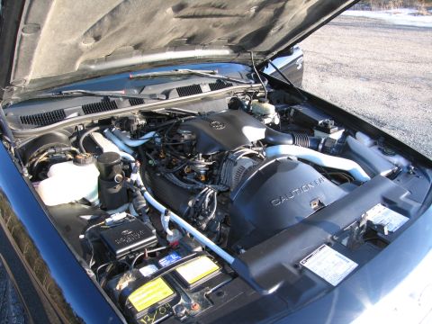 1991 Ford LTD Crown Victoria - The engine bay of a 1991 Ford Crown Victoria LTD is visible with the hood raised, revealing the V8 engine and associated components.