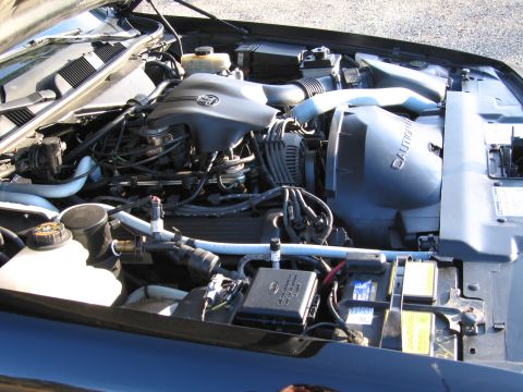 1991 Ford LTD Crown Victoria - Engine bay components including hoses, wires, fuse box, and battery are visible in this close-up shot.