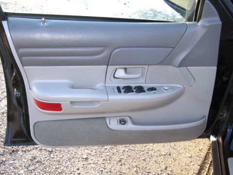 1991 Ford LTD Crown Victoria - Close-up of a car's interior door panel, showing the window controls and door handle.