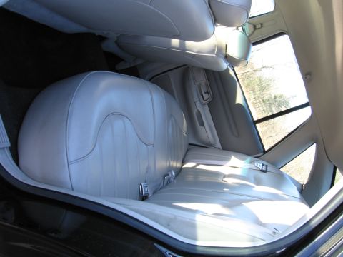 1991 Ford LTD Crown Victoria - Interior view of light gray leather rear seats and door panel in a vehicle.