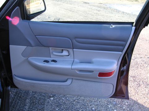 1991 Ford LTD Crown Victoria - The interior of a car door is visible, with gray upholstery and controls.