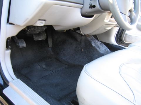 1991 Ford LTD Crown Victoria - The driver's side footwell of a car, showing the pedals and floor mat.