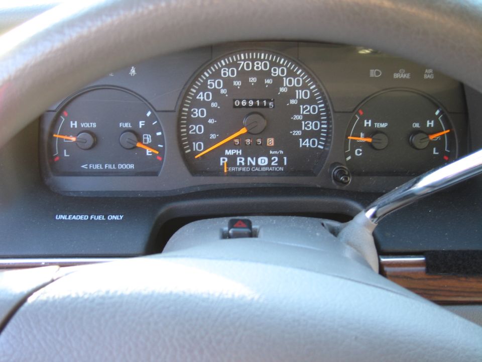 Dashboard gauges showing speed, fuel, volts, temperature, and oil. Odometer reads 069115