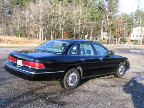 1991 Ford LTD Crown Victoria - Black 1991 Ford Crown Victoria LTD sedan seen from a 3/4 front angle on a gravel surface.