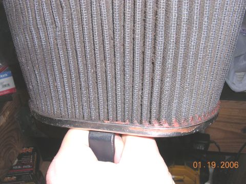 1994 Ford Bronco - A close-up view of a dirty air filter, showing its pleated design and metal frame.