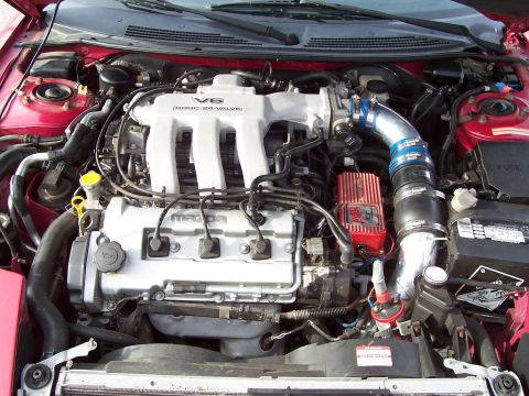1996 Ford Probe - Engine bay view of a Mazda V6 engine, an aftermarket red MSD ignition box and blue intake piping.
