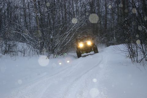 2003 Jeep TJ - An off-road vehicle navigates a snow-covered path through a winter forest.