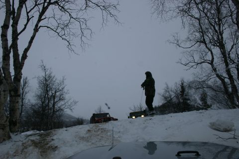 2003 Jeep TJ - Two off-road vehicles are seen in a snowy landscape with a person standing between them.