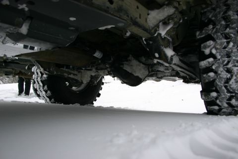 2003 Jeep TJ - Vehicle undercarriage covered in snow, showing tires and frame components.
