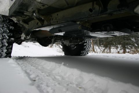 2003 Jeep TJ - The undercarriage of a vehicle is visible, partially submerged in snow.