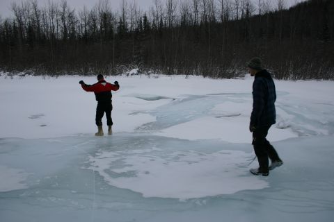 2003 Jeep TJ - Two individuals are on a frozen landscape, with one person in the foreground walking and another in the mid-ground with arms raised.