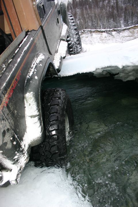 2003 Jeep TJ - Jeep Wrangler navigates icy water, showing off its off-road capability in a winter environment.