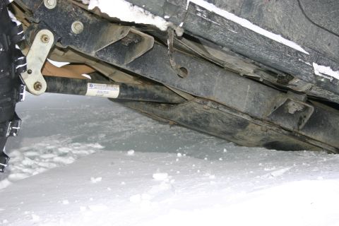 2003 Jeep TJ - Undercarriage of a vehicle partially covered in snow, showing suspension components and a label.