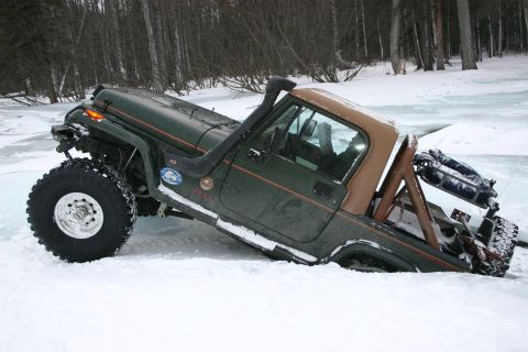 2003 Jeep TJ - Modified Jeep CJ-7 with soft top parked in a snowy outdoor setting.