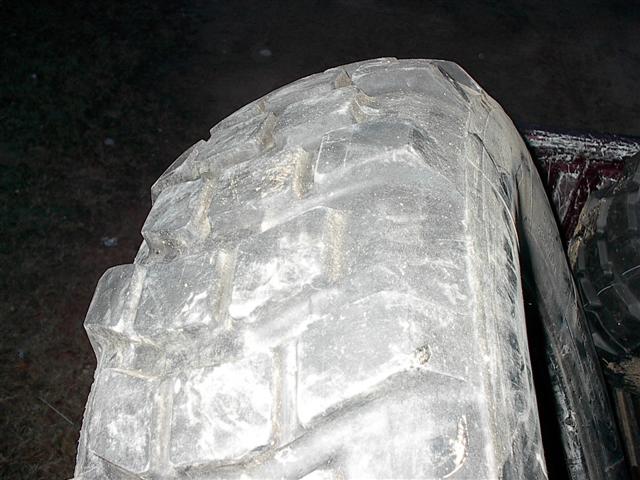 White vinyl truck bed cover, wrinkled and dirty, partially obscuring a dark interior