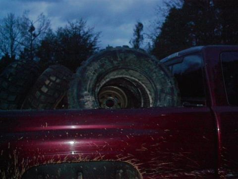 2001 Dodge 1500 - A red truck is seen from the rear in a dimly lit outdoor setting with an archway in the background.