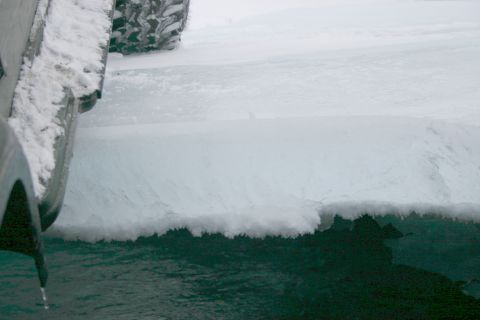 2003 Jeep TJ - A snow-covered Jeep tire and fender are partially visible in this close-up shot.