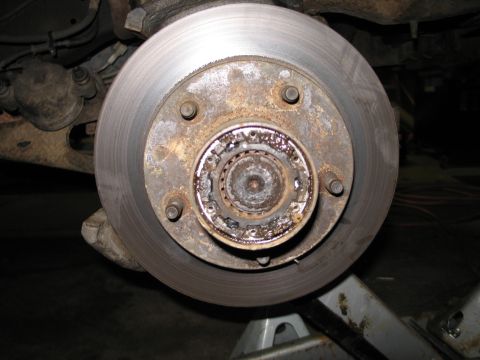 1995 Ford Bronco - This image shows a close-up view of a worn and rusty wheel hub and brake rotor, likely in need of maintenance or replacement.