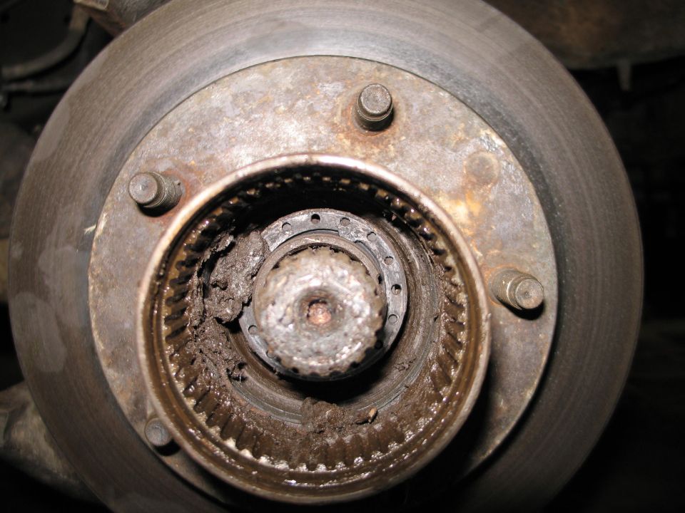 Close-up of a dirty wheel bearing assembly with visible grease and splines