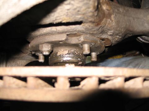 1995 Ford Bronco - Close-up view of a vehicle's wheel bearing assembly, showing bolts and grease.