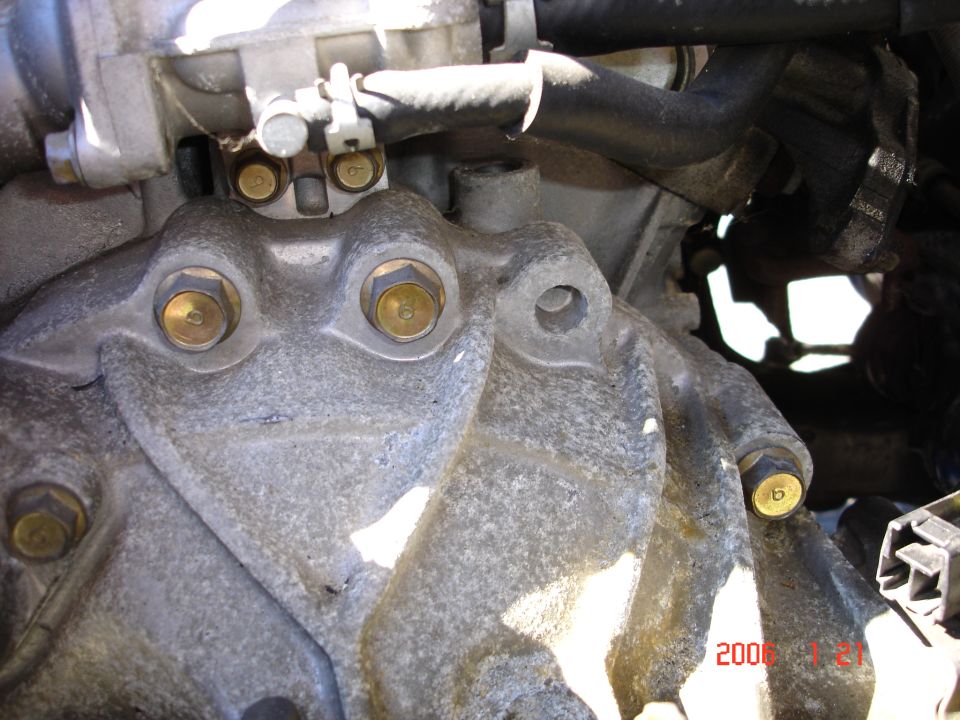 Engine block and transmission housing with visible bolts and hoses. Date stamp reads 2006 1 21