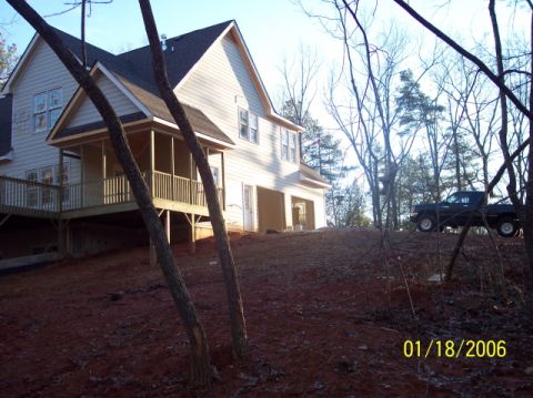 1987 Toyota 4Runner - A dark pickup truck is parked on a dirt hill next to a house that is under construction.