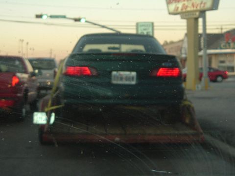 1993 Ford Taurus - Rear view of a green 1993 Ford Taurus being transported on a trailer.