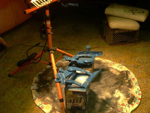 1978 Ford Bronco - Blue metal parts are placed on top of cardboard boxes under a work light.