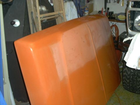 1978 Ford Bronco - An orange hood is shown in a garage setting, with other vehicle parts visible in the background.