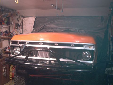1978 Ford Bronco - Front view of a 1978 Ford Bronco in a garage, partially covered.