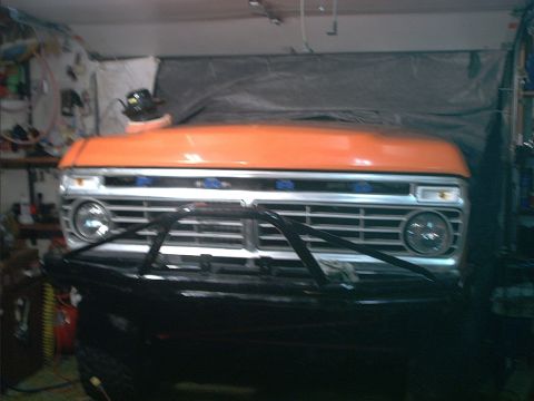1978 Ford Bronco - The front grille and orange hood of a 1978 Ford Bronco are visible in this garage setting.