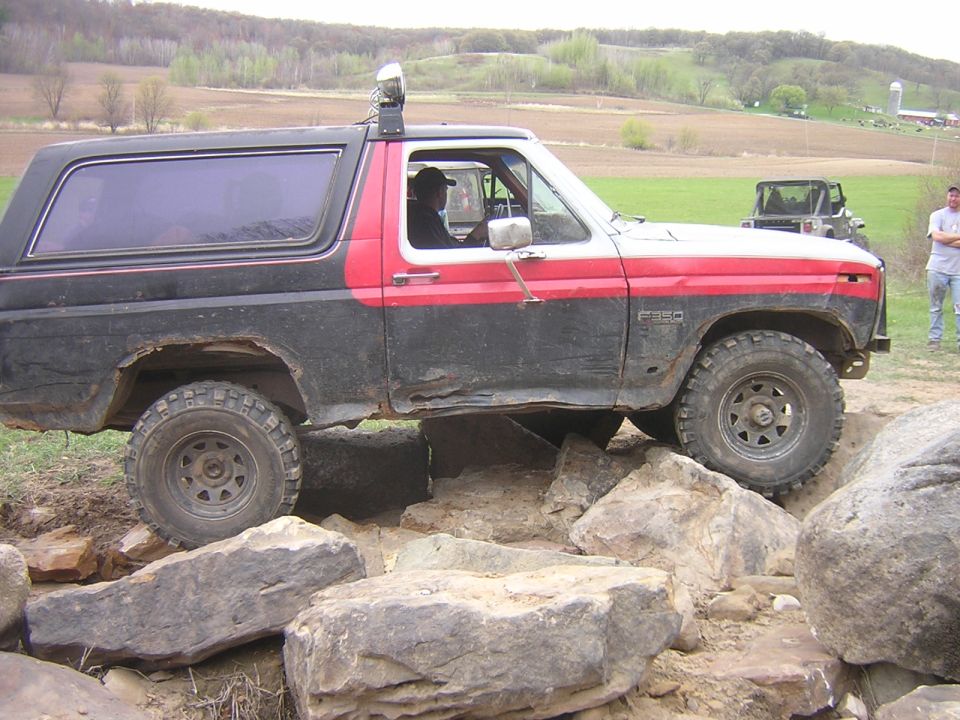 Ford Bronco driving over rocks, another Jeep in background