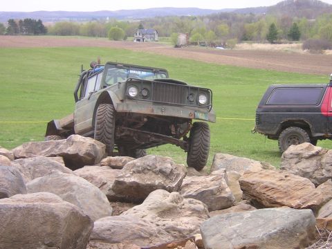 1977 Ford F-150 - Off-road Jeep CJ-8 Scrambler navigates a rocky obstacle course with another vehicle behind it.
