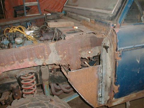 1968 Ford Bronco - A close-up view of a vehicle's undercarriage reveals rusted metal and blue painted sections.