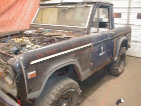 1968 Ford Bronco - 1968 Ford Bronco in a garage, hood is open showing the engine bay.