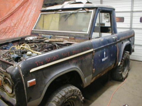 1968 Ford Bronco - A 1968 Ford Bronco is shown with its hood up, revealing the engine bay.