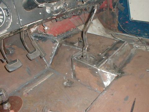 1968 Ford Bronco - A close-up view of a vehicle's undercarriage, revealing rusted metal components and suspension elements.