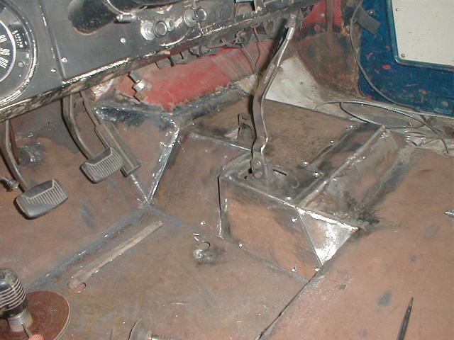 Undercarriage of a vehicle, showing rusted metal and suspension parts