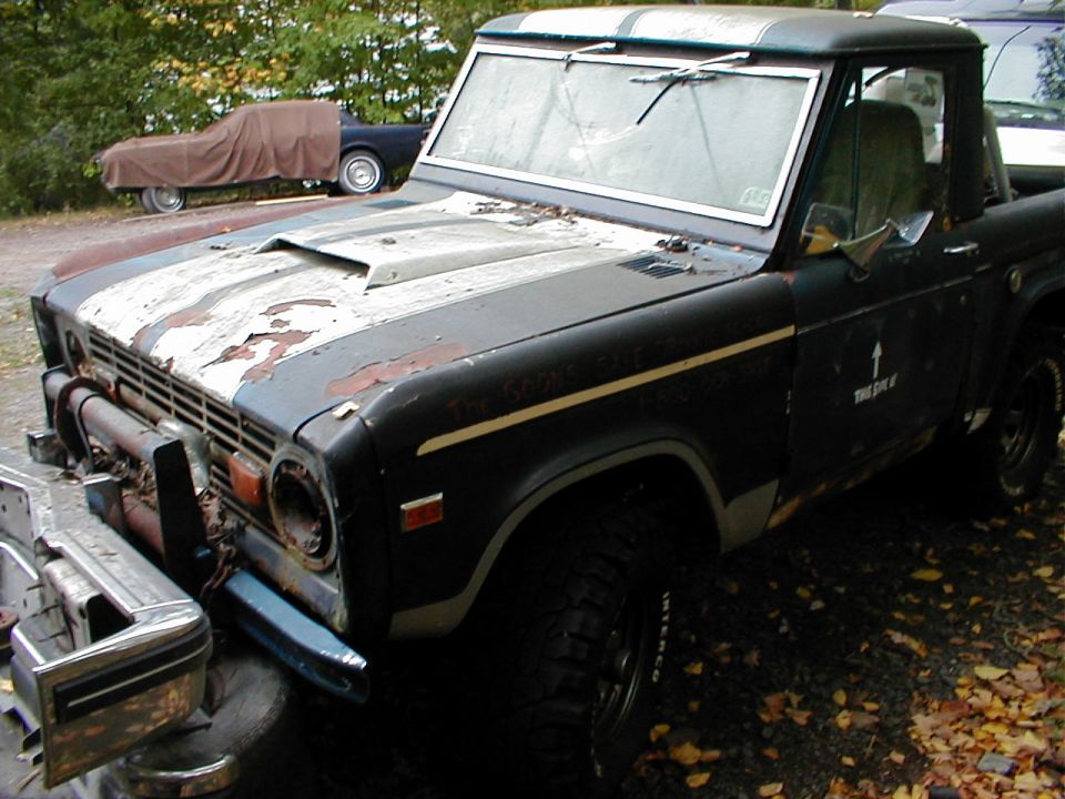 1968 Ford Bronco with peeling racing stripes and a scoop on the hood