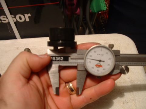 1995 Ford Bronco - A caliper is used to measure a black cylindrical component, with a dial indicator displaying the reading.