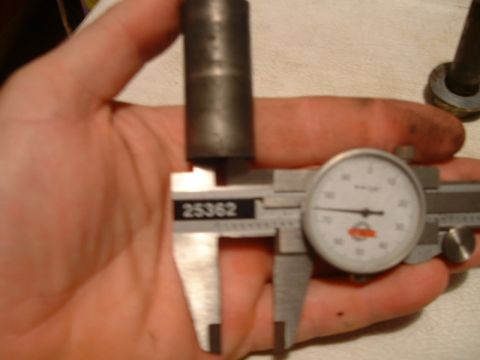 1995 Ford Bronco - A caliper is used to measure the diameter of a metal part, with a dial gauge also visible.
