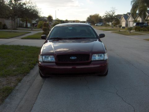2004 Ford Crown Victoria - Front view of a maroon 2004 Ford Crown Victoria parked on a suburban street.