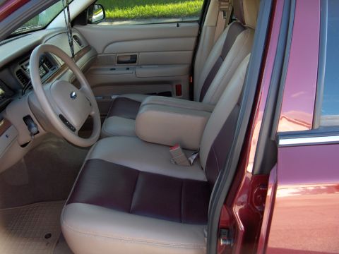 2004 Ford Crown Victoria - The interior of a car features two-tone seats and a tan dashboard.
