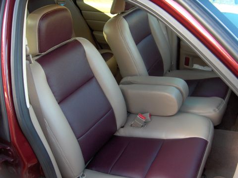 2004 Ford Crown Victoria - The interior features two-tone seats with maroon and tan upholstery, and tan armrests.