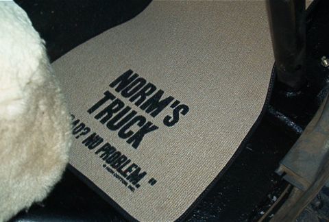 1986 Ford Bronco - A floor mat inside a vehicle reads 'NORM'S TRUCK' and 'BAD? NO PROBLEM.', suggesting a repair or modification.