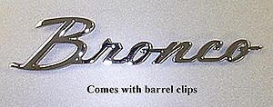 1987 Ford Bronco - A chrome Bronco emblem is shown against a textured background.