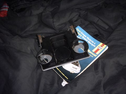 1991 Ford LTD Crown Victoria - A car part and owner's manual are placed on a black fabric surface.
